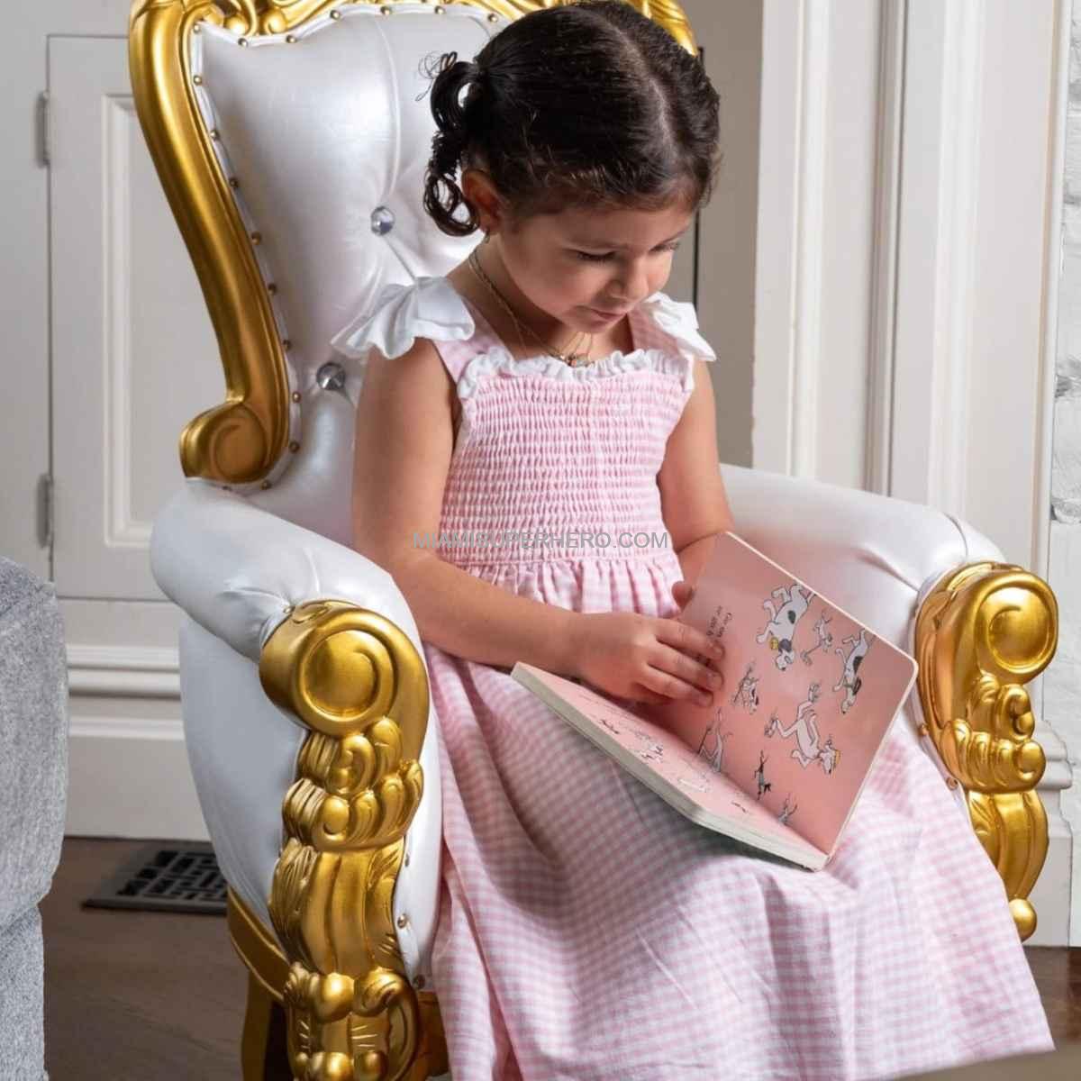 Toddler celebrating first birthday seated on luxury baby throne