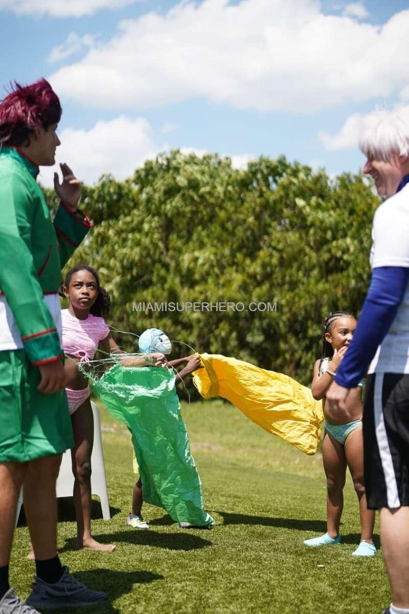Gon and Killua characters running a sack race with kids