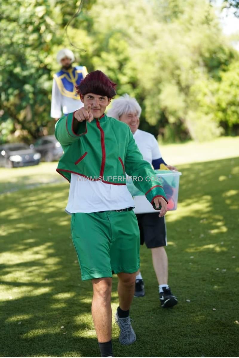 Gon character pointing at the camera at an outdoor party